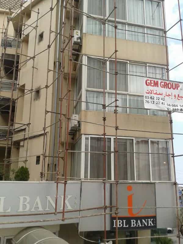 سقالات واجهة من 6 طوابق على مبنى تجاري في جونيه مع علامة Gem Group.